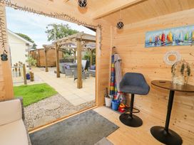 A garden room with a table and a chair at Cae Berllan near Pwllheli