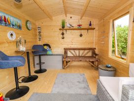 A garden room with seating and decorative items at Cae Berllan in Mynytho near Pwllheli