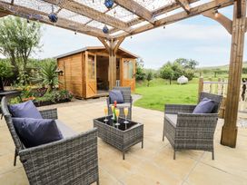 An outdoor seating area with chairs and table at Cae Berllan Mynytho near Pwllheli