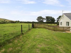 An outdoor area with grass and a fence at Cae Berllan in Mynytho near Pwllheli
