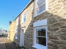 An exterior view of a stone cottage with windows and door at Widgeons Keel in Flushing