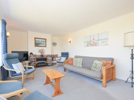 A living room with seating and television at Zapadiah in Polzeath