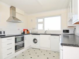 A kitchen with appliances including an oven and washing machine at Zapadiah in Polzeath
