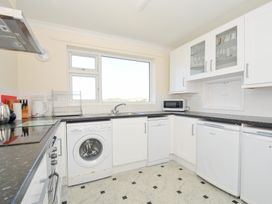 A kitchen with a washing machine and microwave at Zapadiah in Polzeath