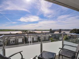 A balcony with chairs and a table overlooking a river at Slipway 15 in Rock