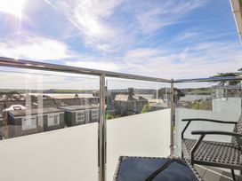 A balcony with chairs and a table overlooking water and buildings at Slipway 15 in Rock