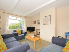 A living room with a television and a bookshelf at Avoca Rock