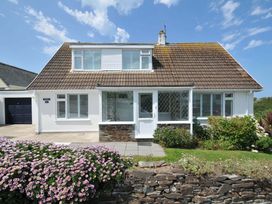 A house with a flower bed and garage at Sunset in Polzeath