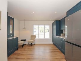 A kitchen with cabinets and a fridge at Sunset in Polzeath