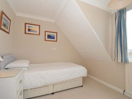A bedroom with a bed and pictures on the wall at Sunset in Polzeath