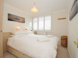 A bedroom with a bed and bedside lamps at Sunset in Polzeath