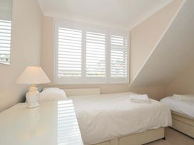 A bedroom with two single beds and a window at Sunset in Polzeath