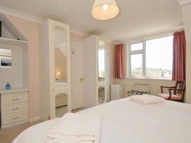 A bedroom with a double bed and wardrobe at Sunset in Polzeath