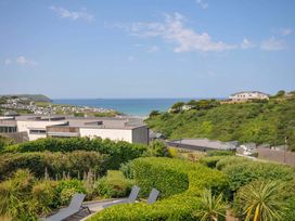 A view of houses and the sea from a garden at Sunset in Polzeath
