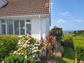 A garden with plants and a view of the sea at Sunset in Polzeath