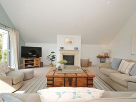 A living room with a coffee table and television at Farlands in Daymer Bay