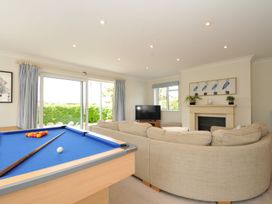 A living room with a pool table and sofa at Farlands in Daymer Bay
