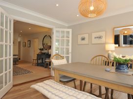 A dining room with a table and chairs at Farlands in Daymer Bay
