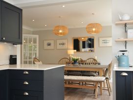 A kitchen with a dining area featuring a table and chairs at Farlands in Daymer Bay