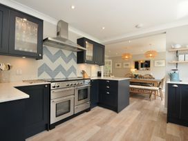 A kitchen with stove and dining area at Farlands in Daymer Bay