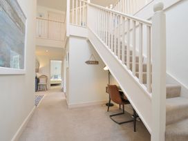 A hallway with a staircase and desk at Farlands in Daymer Bay
