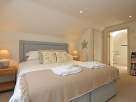 A bedroom with a bed and a lamp at Farlands Daymer Bay