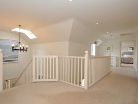 A hallway with staircase and doorways at Farlands in Daymer Bay