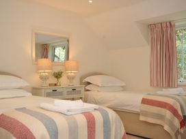 A bedroom with two beds and a mirror at Farlands in Daymer Bay