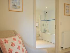 A view of a bathroom with a bathtub and shower from a living area at Farlands in Daymer Bay
