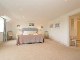A bedroom with a bed, bedside tables, and artwork at Farlands, Daymer Bay