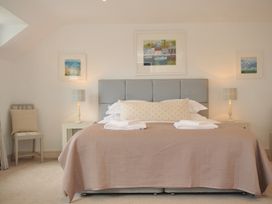 A bedroom with a bed and paintings at Farlands in Daymer Bay