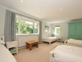 A bedroom with multiple beds and a wardrobe at Farlands in Daymer Bay