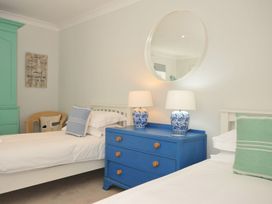 A bedroom with two beds and a blue dresser at Farlands in Daymer Bay