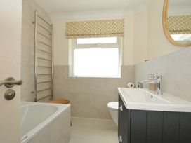 A bathroom featuring a tub, toilet, sink, and towel rail at Farlands Daymer Bay