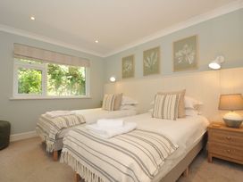A bedroom with twin beds and a nightstand at Farlands in Daymer Bay