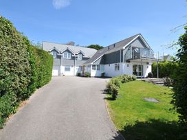 An outdoor view of a house with a driveway and garden at Farlands in Daymer Bay