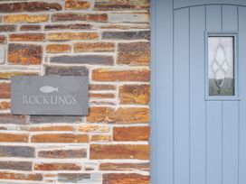 A stone wall with a blue door and a nameplate at Rocklings in Rock