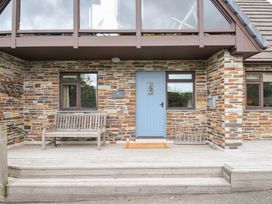 A front entry with a blue door and wooden bench at Rocklings in Rock