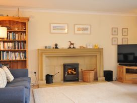 A living room with a fireplace and bookshelves at Tregillan in Rock