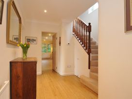 A hallway with a staircase and wooden cabinet at Tregillan in Rock