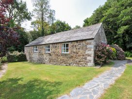 A stone building with windows in a garden at Mill Pond Rock