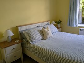 A bedroom with a bed and nightstand at Burwyn in Polzeath