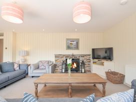 A living room with a fireplace and sofa at Porthilly Brook in Rock