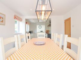 A dining room with a table and chairs at Porthilly Brook in Rock