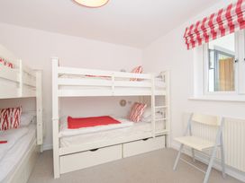 A bedroom with bunk beds and a chair at Porthilly Brook in Rock