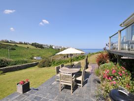 A garden with a table and chairs at Cartway Cove in Port Isaac