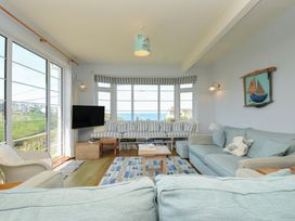 A living room with a television and sofa at Cartway Cove in Port Isaac