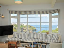 A living room with a view of the sea and a comfortable sofa at Cartway Cove in Port Isaac