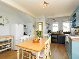 A kitchen with a table and chairs at Cartway Cove in Port Isaac
