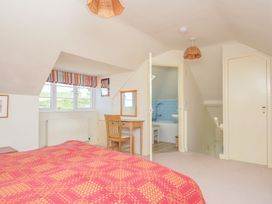 A bedroom with a bed, desk, and a bath in the adjoining bathroom at Cartway Cove in Port Isaac